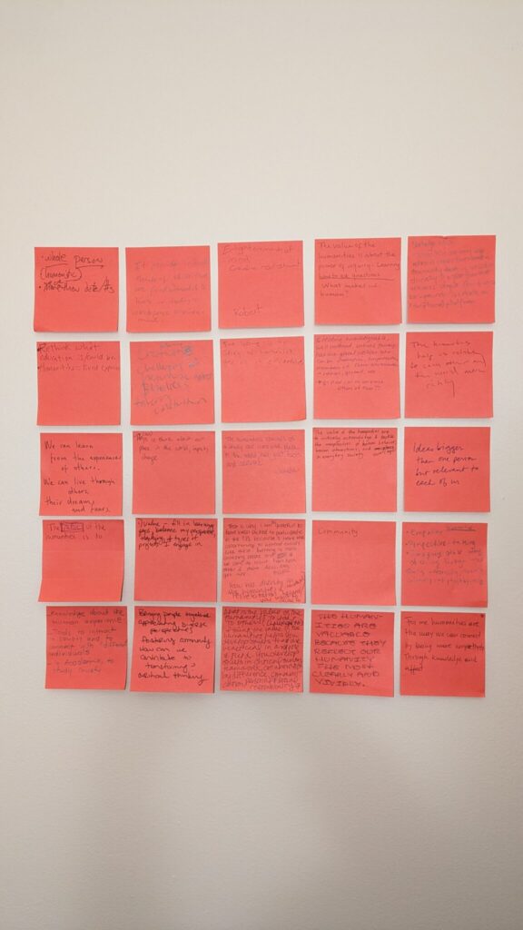 Red post-it notes with illegible hand writing on them organized into 5 columns of 5 rows. 